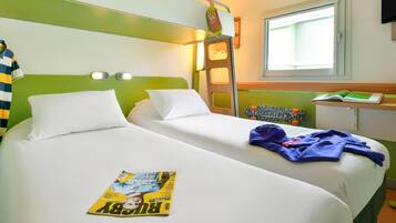A hotel room with two beds, a window, a desk, and a ladder.