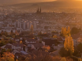 A cityscape with residential buildings and a prominent cathedral in the background.