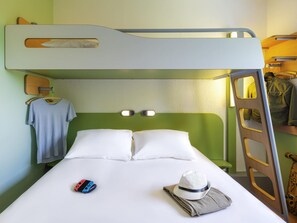 A bunk bed room with a green wall, a wooden ladder, a white pillow, a hat, and a Nintendo Switch on the bed. - Ibis Budget Clermont Ferrand Sud Aubière (Aubiere)