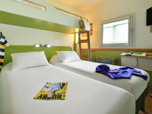 A hotel room with two beds, a ladder, a window, and a magazine on one bed. - Ibis Budget Clermont Ferrand Sud Aubière (Aubiere)