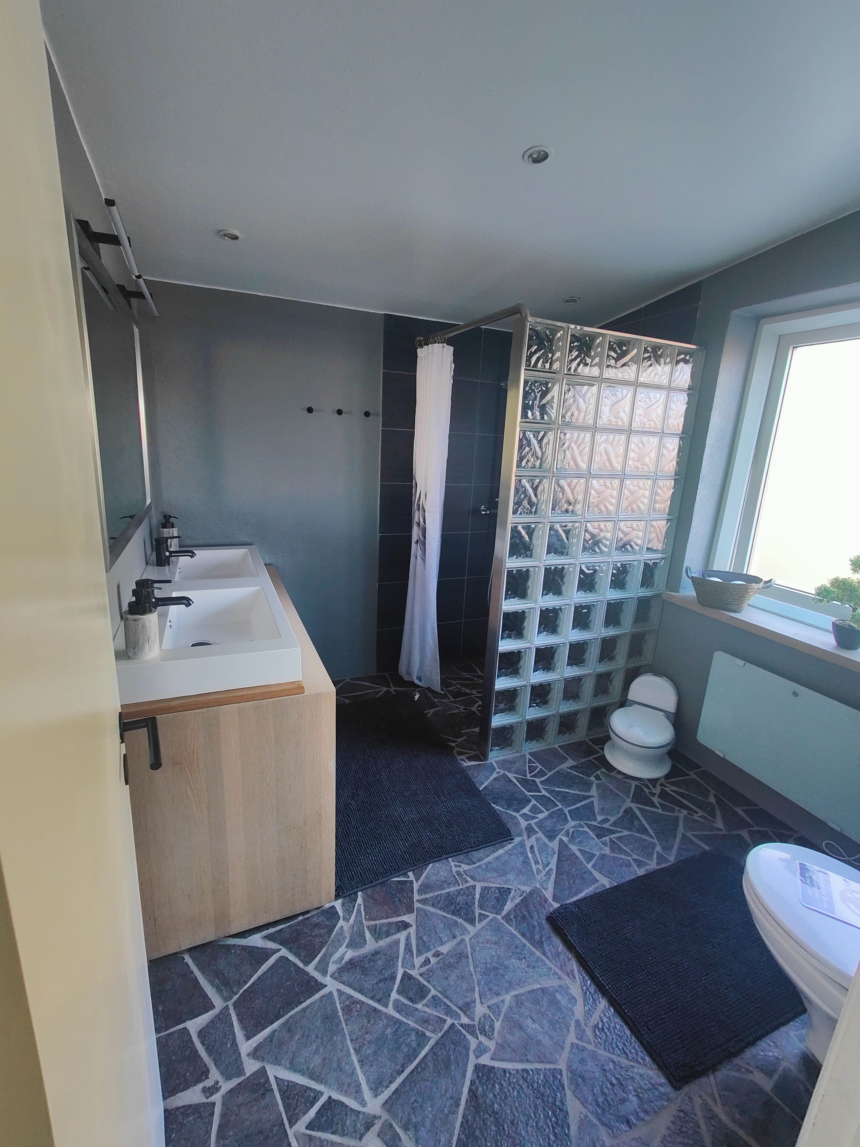A modern bathroom with a bathtub, shower, and toilet.