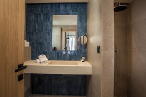 A modern bathroom with a beige sink, a large mirror, and a shower area. - Este Elegant Suites and Villas (Rhodes)