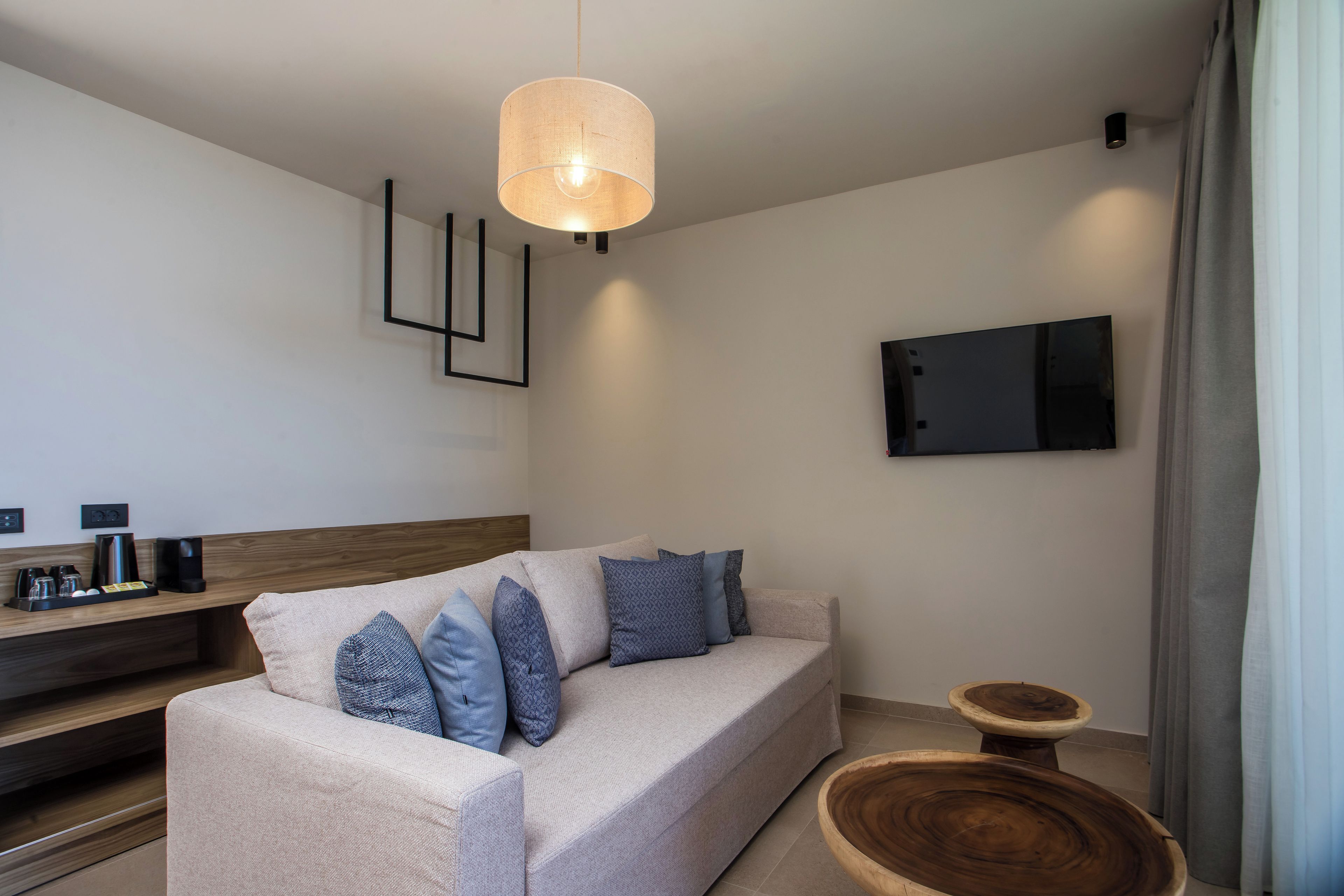 A modern living room with a sofa, coffee table, and a mounted TV.