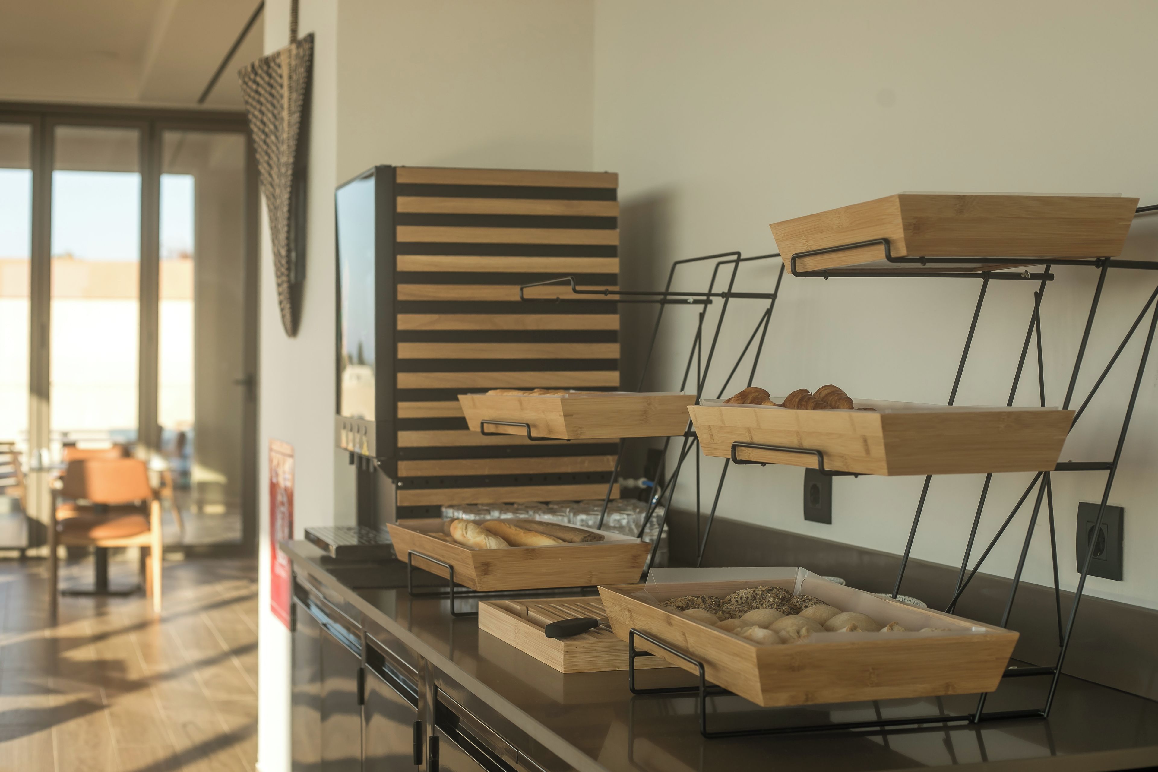 Preparación de un bufé de desayuno con bandejas de madera y una cocina moderna.