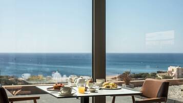 Une table dressée pour le petit-déjeuner, avec vue sur la mer.