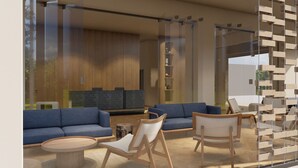A modern lounge area with blue sofas, wooden chairs, and a glass partition. - Este Elegant Suites and Villas (Rhodes)