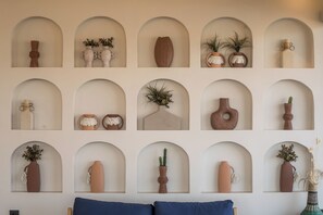A wall with multiple arched niches containing various decorative items.