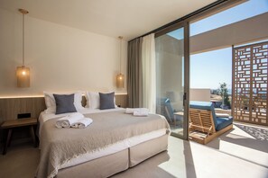 Una habitación de hotel moderna con una cama grande, dos lámparas de noche, un balcón con vistas y una mesita de noche de madera.