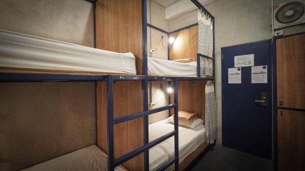 A dormitory room with bunk beds, a door with a lock, and a small desk with a chair. - Arawana Hoft Hostel (Bangkok)