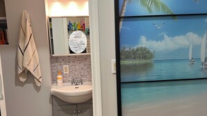 A bathroom with a sink, mirror, towel rack, and a trash bin. - Charming 1-bedroom/ kitchen n a house in beautiful Toronto with WiFi, AC, Female (Toronto)