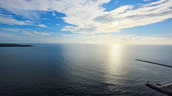 Ruhiges Meer mit klarem Himmel und weiter Küstenlinie.
