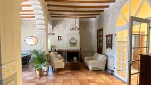 Una habitación amplia con techo alto, chimenea y un gran arco que da al exterior.