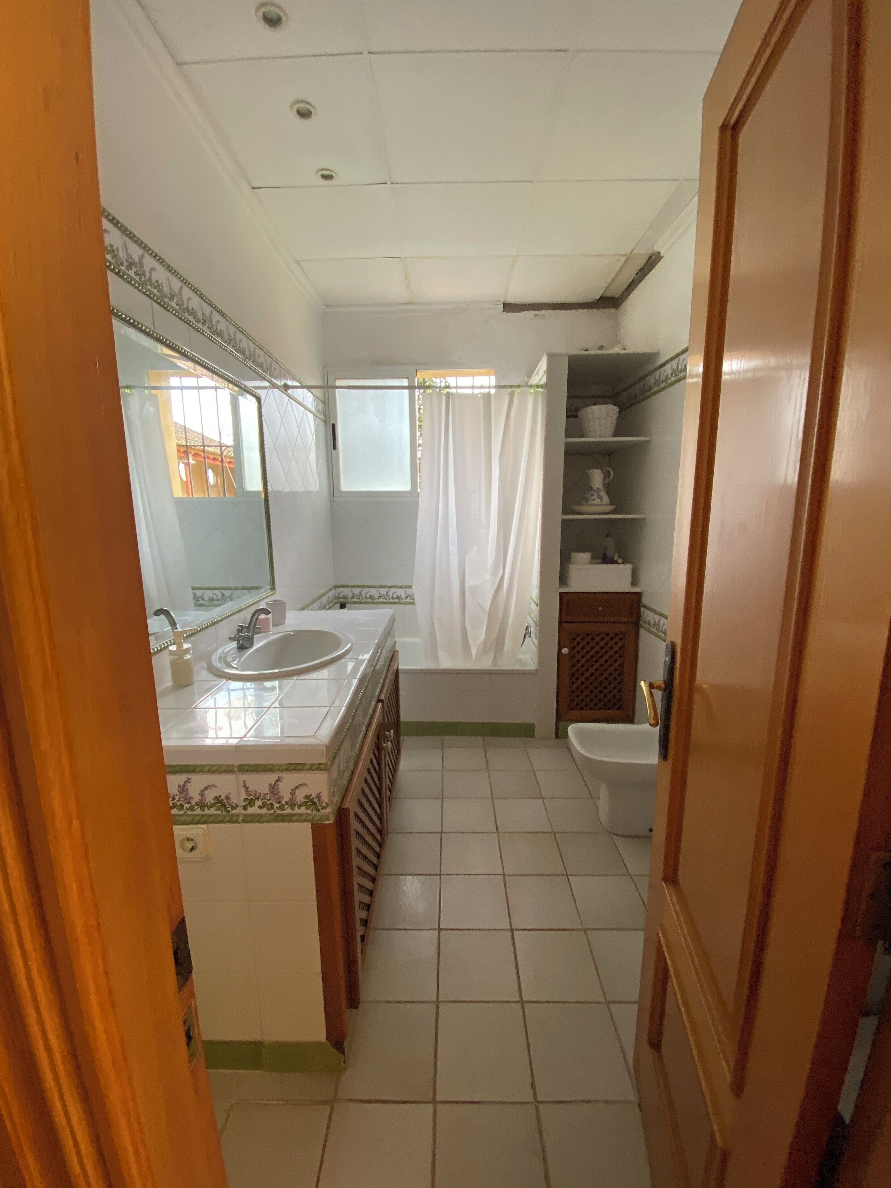 A bathroom with a sink, mirror, bathtub, and toilet.
