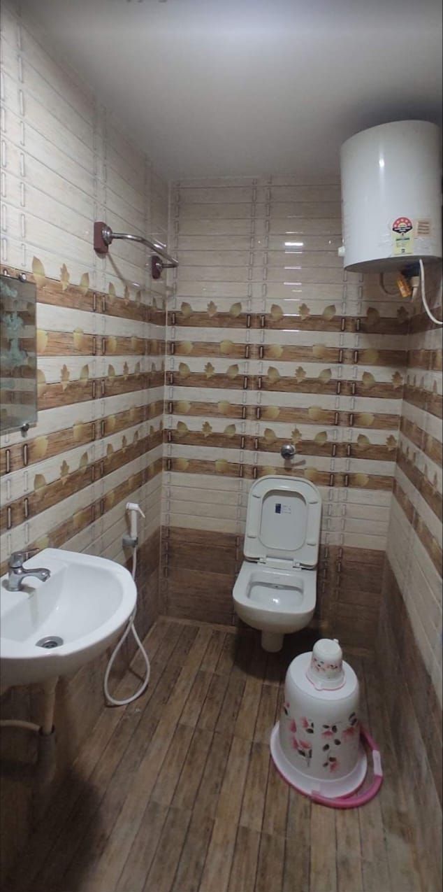 Een kleine badkamer met toilet, wastafel en douche.