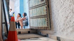 A rustic interior with a wooden ceiling, a weathered door with metal studs, and a tiled floor. - Riad la santa (Chefchaouen)