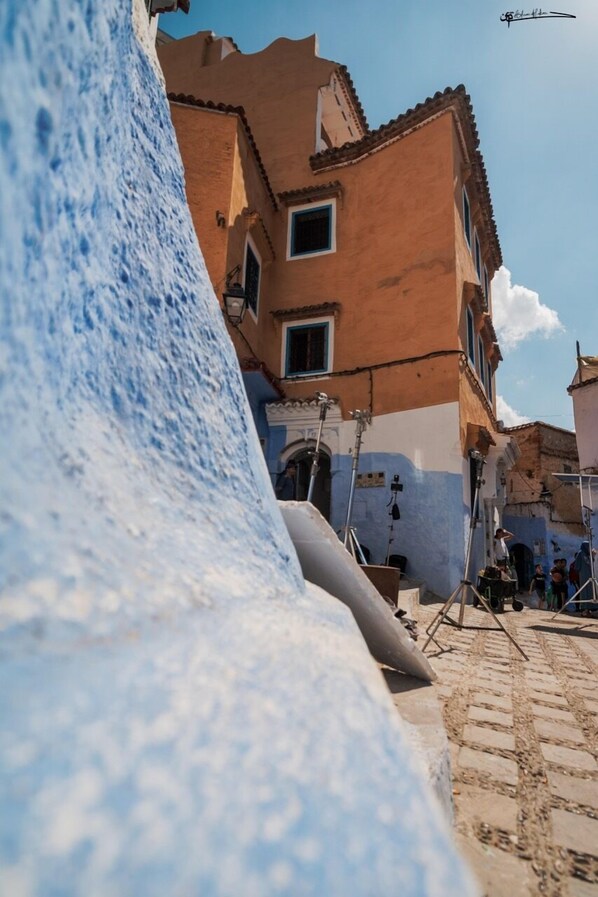 A street view with buildings, a cobblestone path, and a clear blue sky.