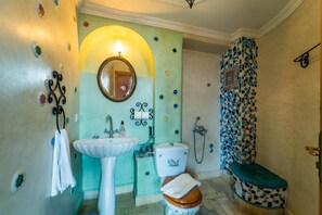 A bathroom with a sink, toilet, and shower.