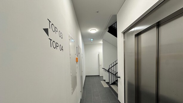 A corridor with directional signs to 'TOP 03' and 'TOP 04'. - Stylish Garden Apartment in Vienna – Peaceful Retreat near Schönbrunn Palace (Wien)