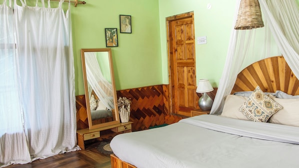 Cozy retreat with a large bed, wooden wardrobe, and stylish mirror.