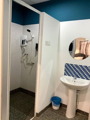 A bathroom with a shower, a sink, a mirror, and a blue tiled backsplash. - 39 Love Lane - Smart Intelligent Inn (George Town)