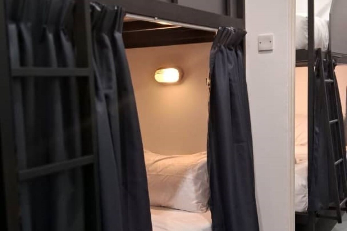 A room with bunk beds, a desk, and a chair.