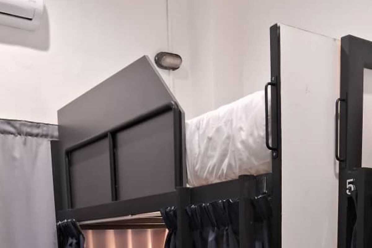 A bunk bed with a headboard, a pull-out desk, and a curtain.