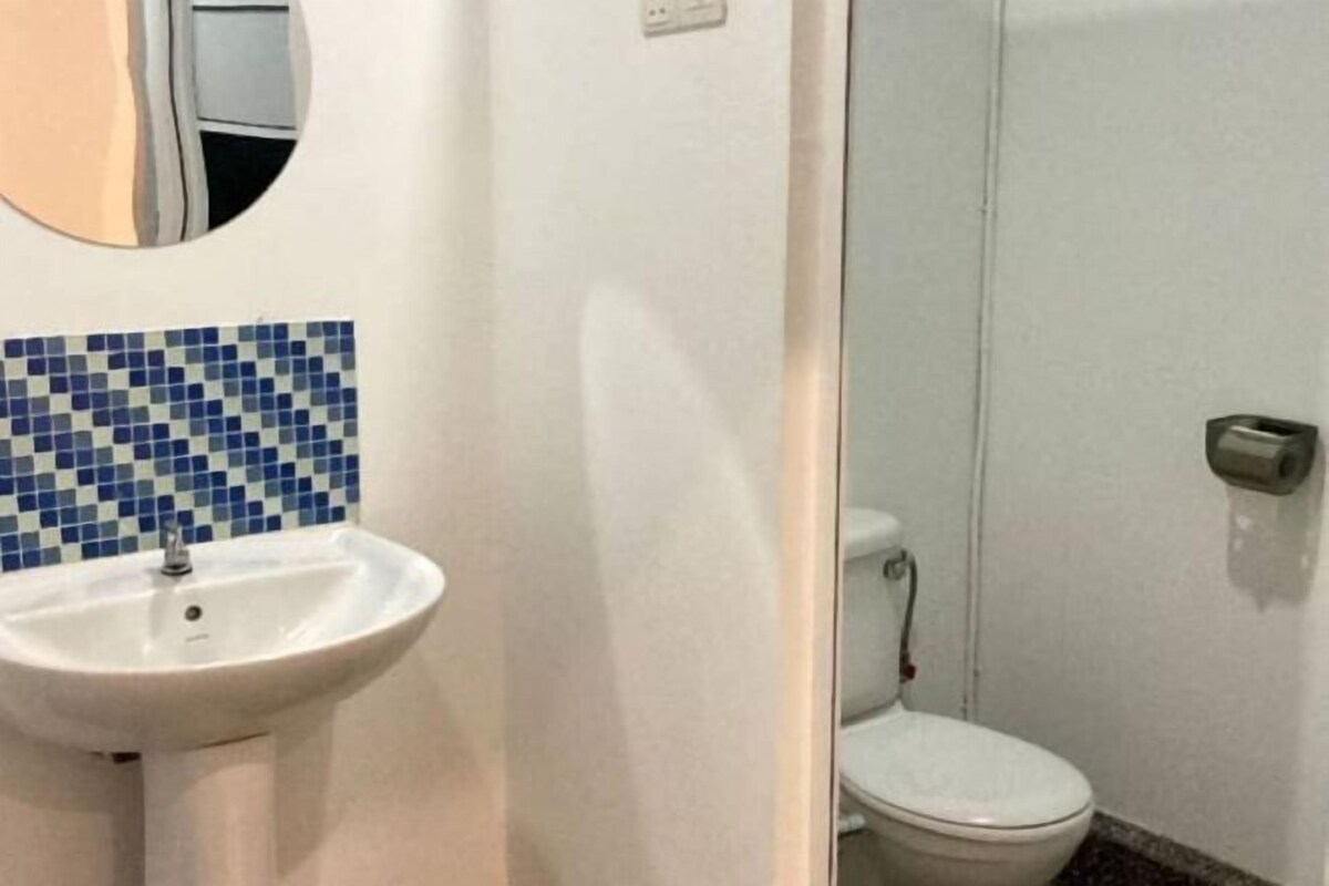 Ein Badezimmer mit weißem Waschbecken, Toilette und einer Wand mit blauen Fliesen.