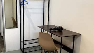 Una habitación compacta con un armario plegable, una mesita y una silla.