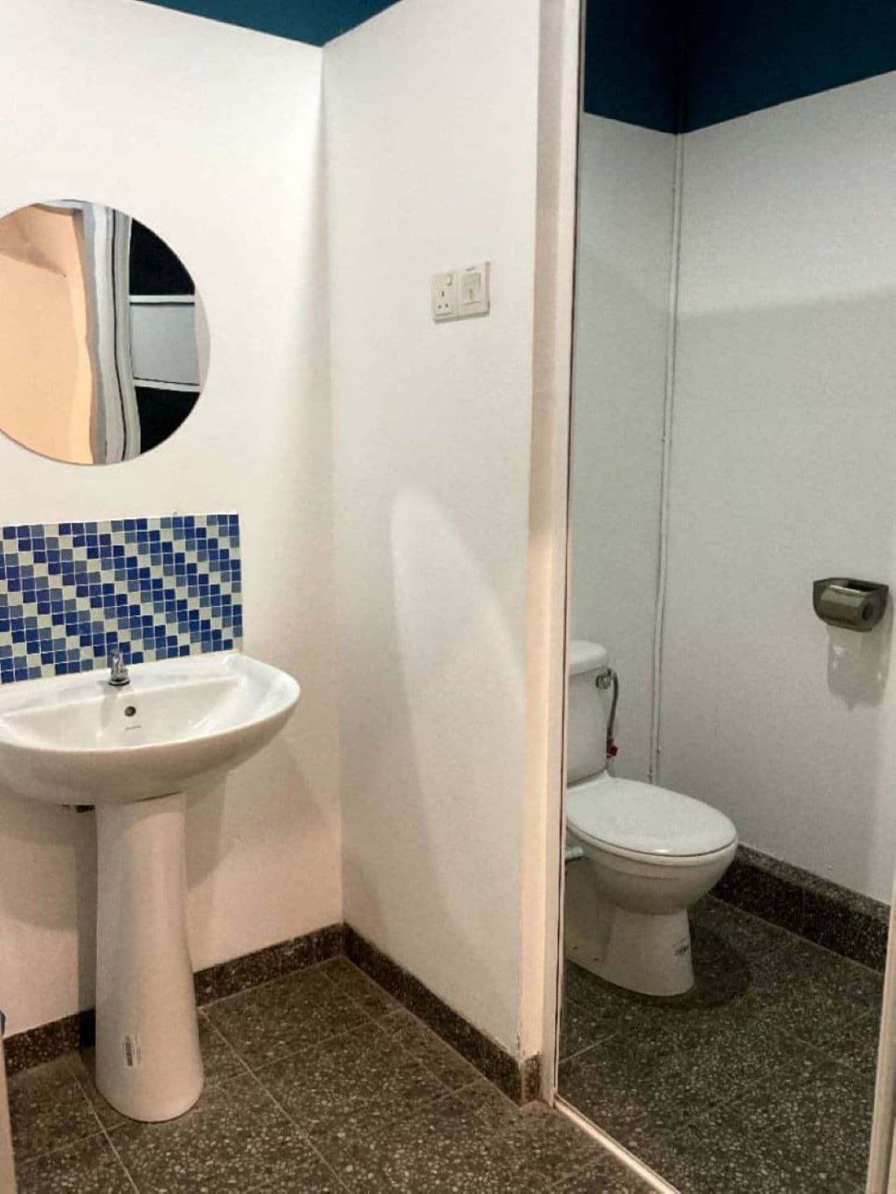 Un baño con lavamanos blanco, inodoro y espejo.