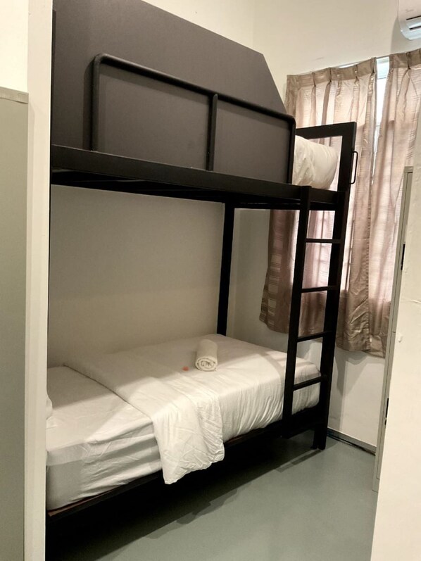 A bunk bed with a ladder, a white mattress, and a rolled-up towel. - 39 Love Lane - Smart Intelligent Inn (George Town)