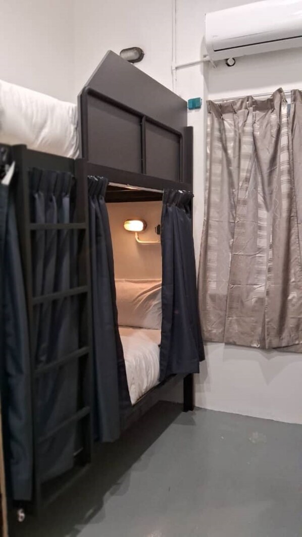 A bunk bed with curtains, a bedside lamp, and an air conditioning unit. - 39 Love Lane - Smart Intelligent Inn (George Town)