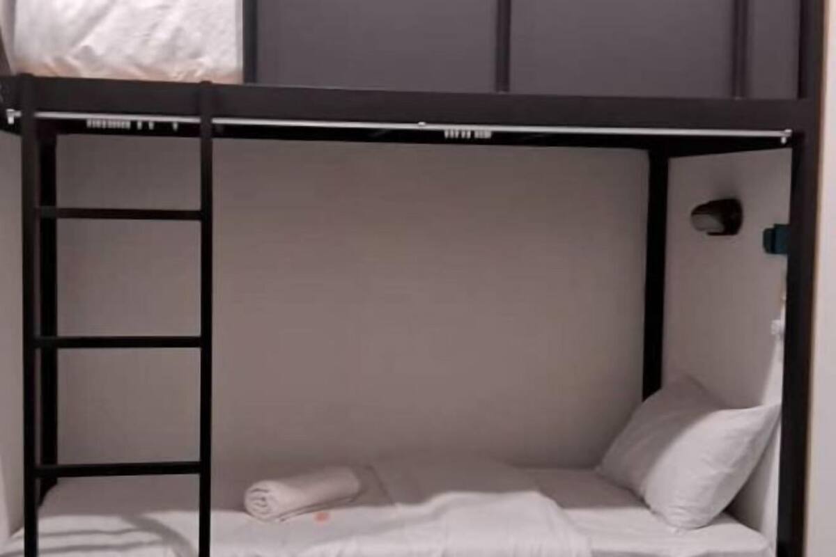A bunk bed with a ladder, a pillow, and a rolled towel.