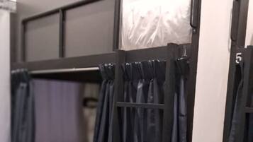 A bunk bed with black curtains and a white mattress.