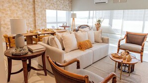 A living room with a sofa, chairs, a coffee table, and a lamp.