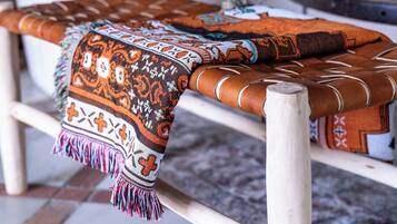 Un sofá con cojines estampados y una manta tejida.