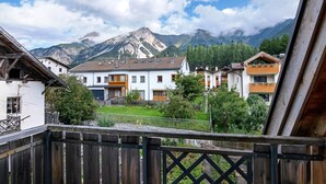 A mountain village with traditional wooden houses, a paved pathway, and a mountain backdrop. - Apartment 'Am Reschensee' with Mountain View, Balcony and Wi-Fi (San Valentino Alla Muta)