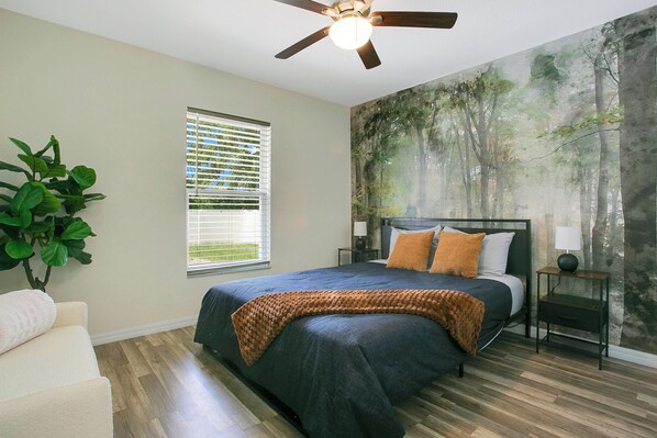 A bedroom with a large bed, a ceiling fan, a window with blinds, a nightstand, a lamp, and a wall mural. - POOL ~ NEAR TO SPRINGS ~ WEC ~ TRAILS ~ SHOPPINGS ~OCALA DOWNTOWN
9beds 4bedroom (Ocala)