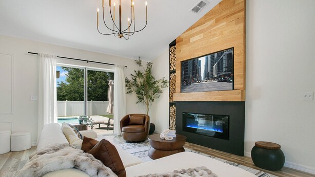 Una sala moderna con un sofá, una chimenea y un televisor montado en la pared.