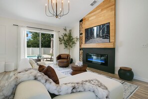A modern living room with a sofa, a fireplace, and a television mounted on the wall. - POOL ~ NEAR TO SPRINGS ~ WEC ~ TRAILS ~ SHOPPINGS ~OCALA DOWNTOWN
9beds 4bedroom (Ocala)