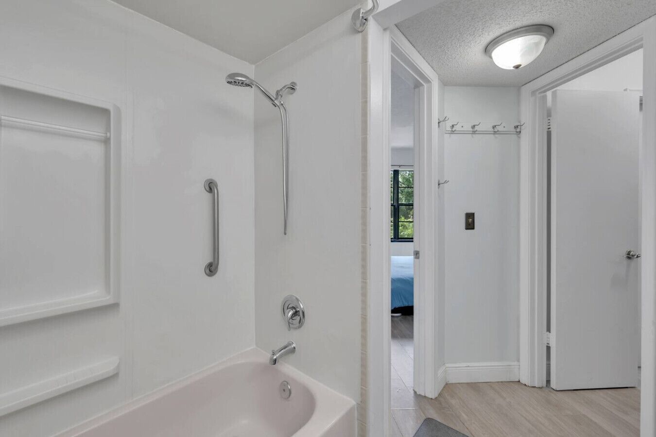 Een moderne badkamer met een bad, een douche en een toilet.