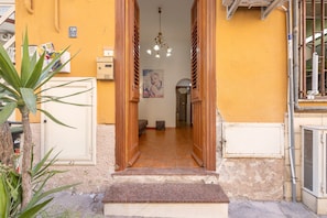 Un acceso a una habitación con suelo de baldosas, una lámpara colgante y un cartel en la pared.