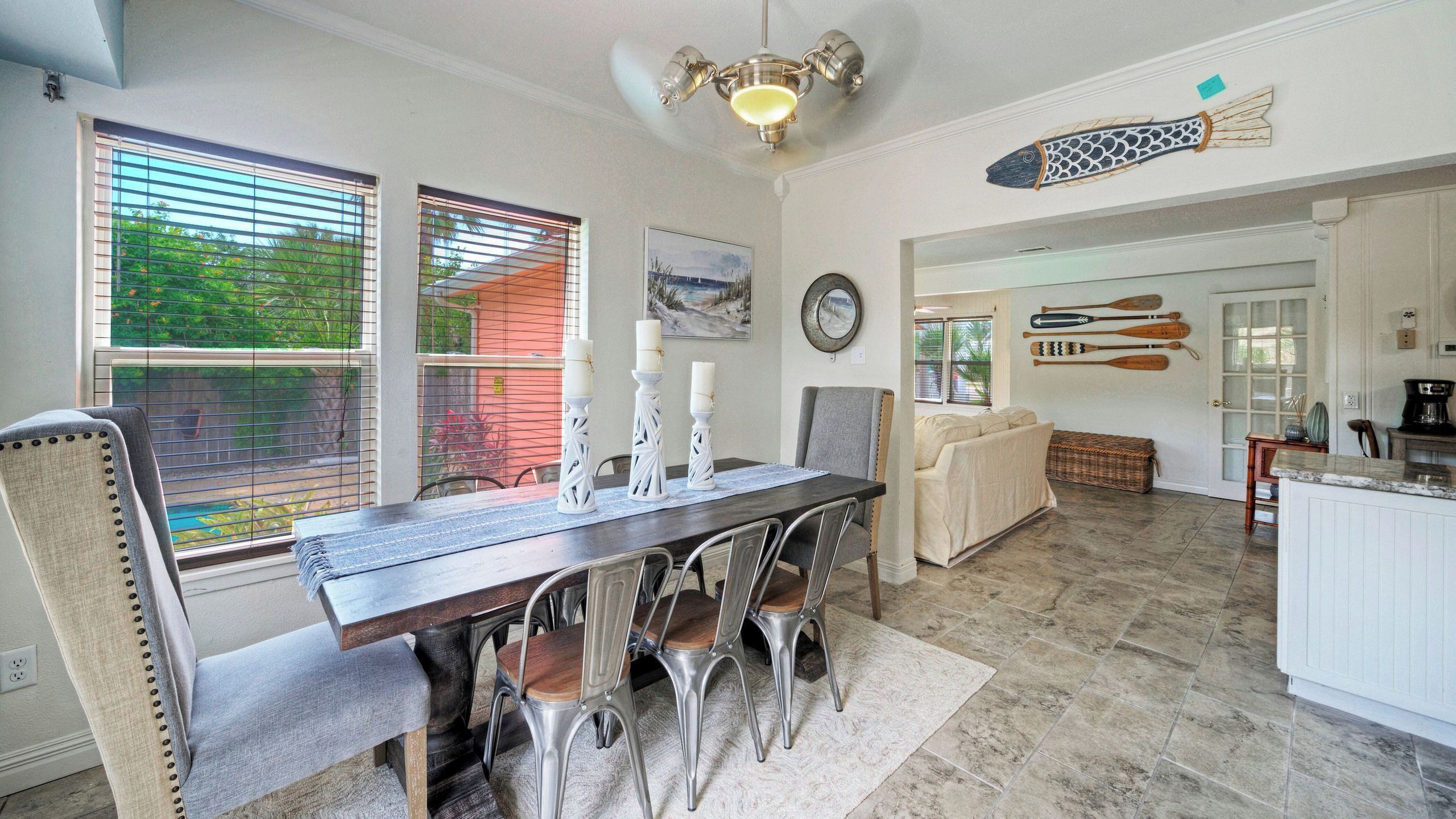 A dining area with a dark wooden table, metal chairs, and a chandelier.