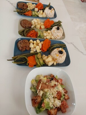 Enjoy a delicious meal at this elegant dining table, set with plates of rice, vegetables, and a savory meat dish.