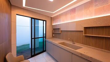 A modern kitchen with a large window, a built-in sink, and a wooden accent wall.