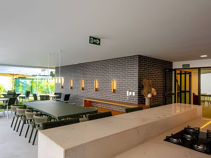 Uma área de recepção moderna com parede de tijolos, balcão e espaço de estar com mesas e cadeiras.