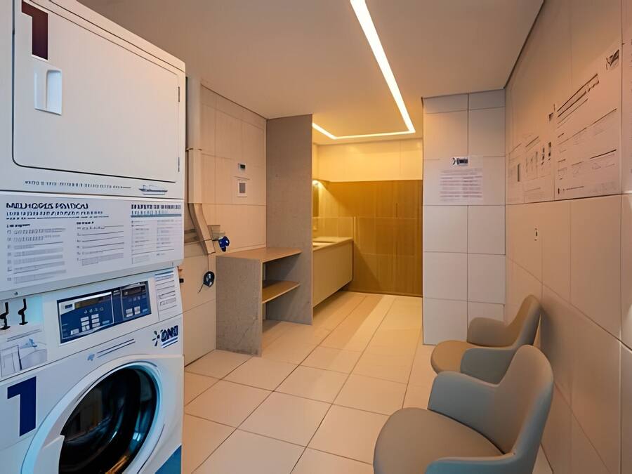 A laundry room with a washing machine, a drying rack, and a seating area.