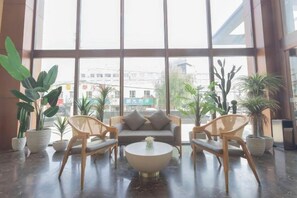A spacious indoor area with large windows, a sofa, two chairs, and a coffee table. - Bali Holiday Inn (Shenyang Nanta) (Shenyang)