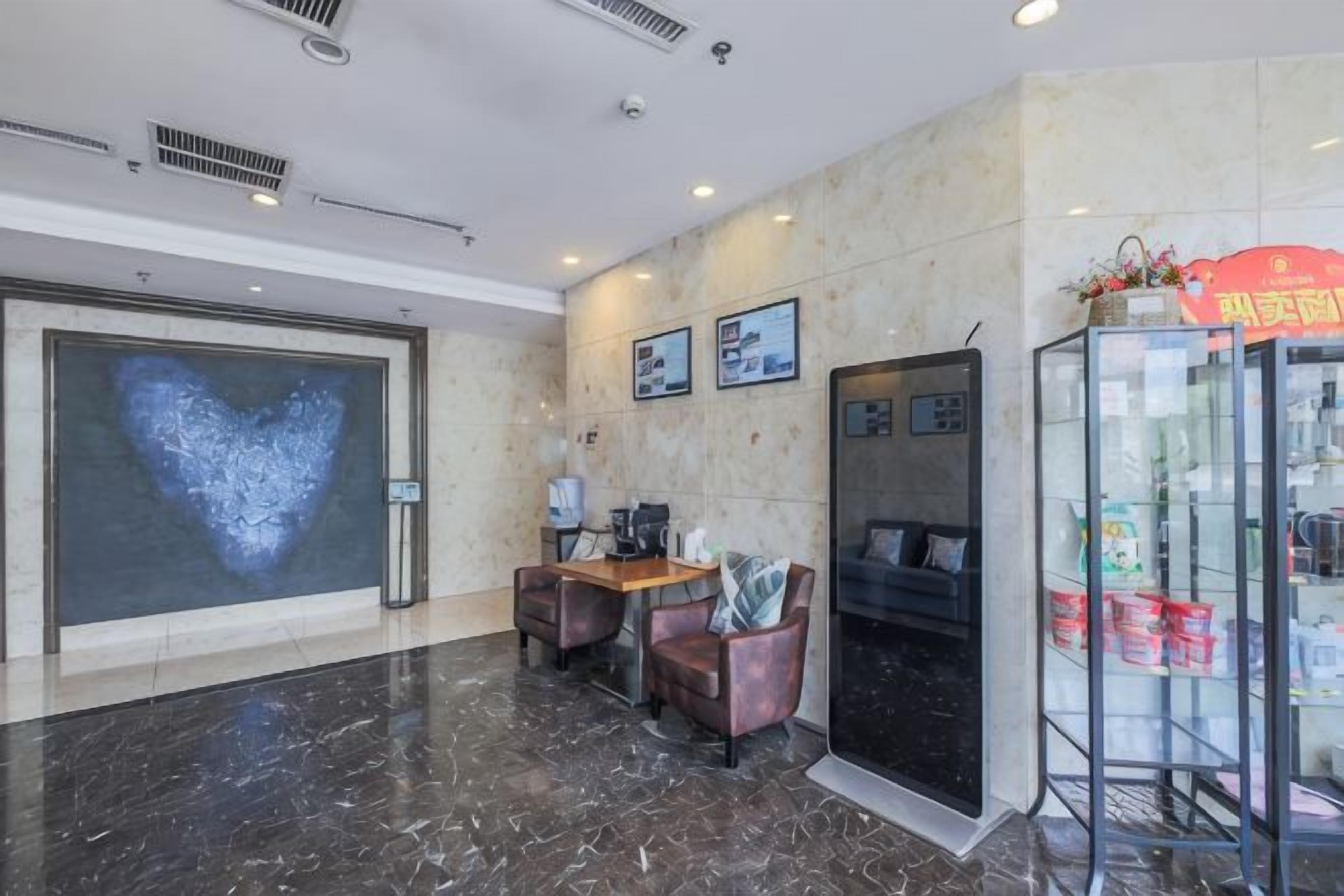 A lobby with a reception desk, seating area, and a glass display case.