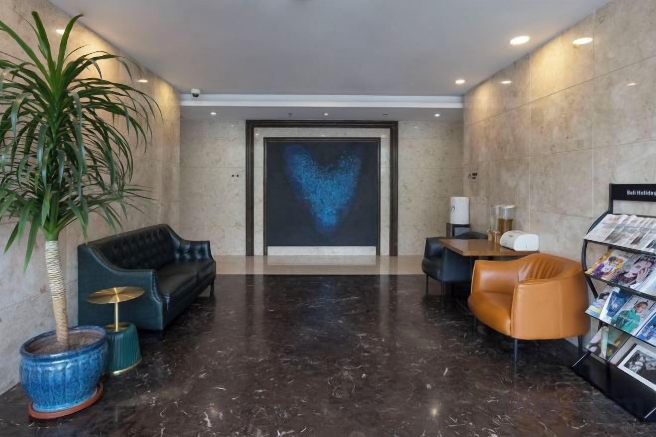 A lobby with a heart-shaped projection, seating areas, a reception desk, and a magazine rack.