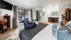 A spacious bedroom with a large bed, a wardrobe, a flat-screen TV, and a sliding glass door leading to a balcony. - Geraldine Drive by Avantstay Hot Tub, Views, Walk to Trails + Game Room (Incline Village)